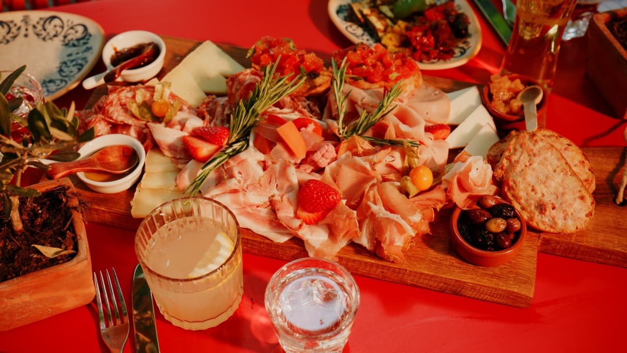 Üppige toskanische Wurst- und Käseplatte mit Rosmarin und Erdbeeren