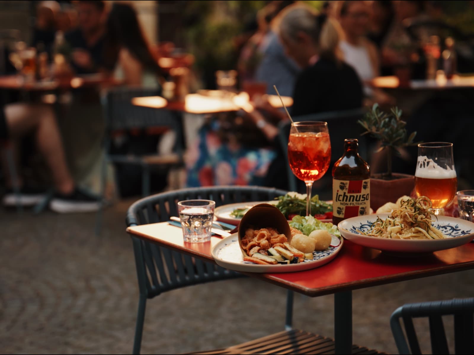 Terrassentisch mit Pasta, Fritto misto und Bier am Abend